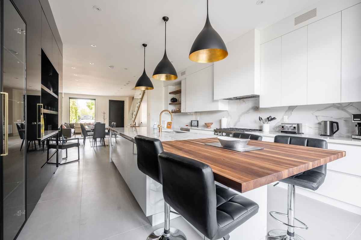 a kitchen with a wooden table and black chairs