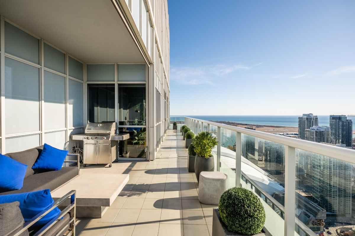a balcony with a couch and a grill on it